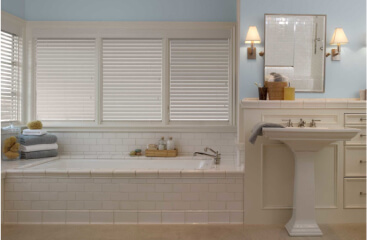 Faux Wood Blinds on four windows above a tiled bath tub