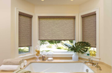 Roller Shades on bay windows above a large bath tub