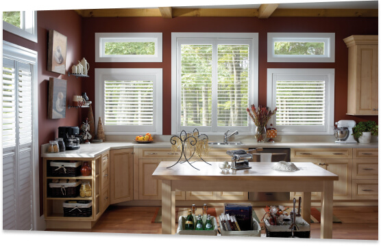 Shuttered windows letting day light into a farm house style kitchen