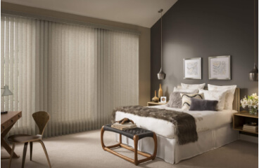 Vertical blinds closed casting dim light in a modern bedroom