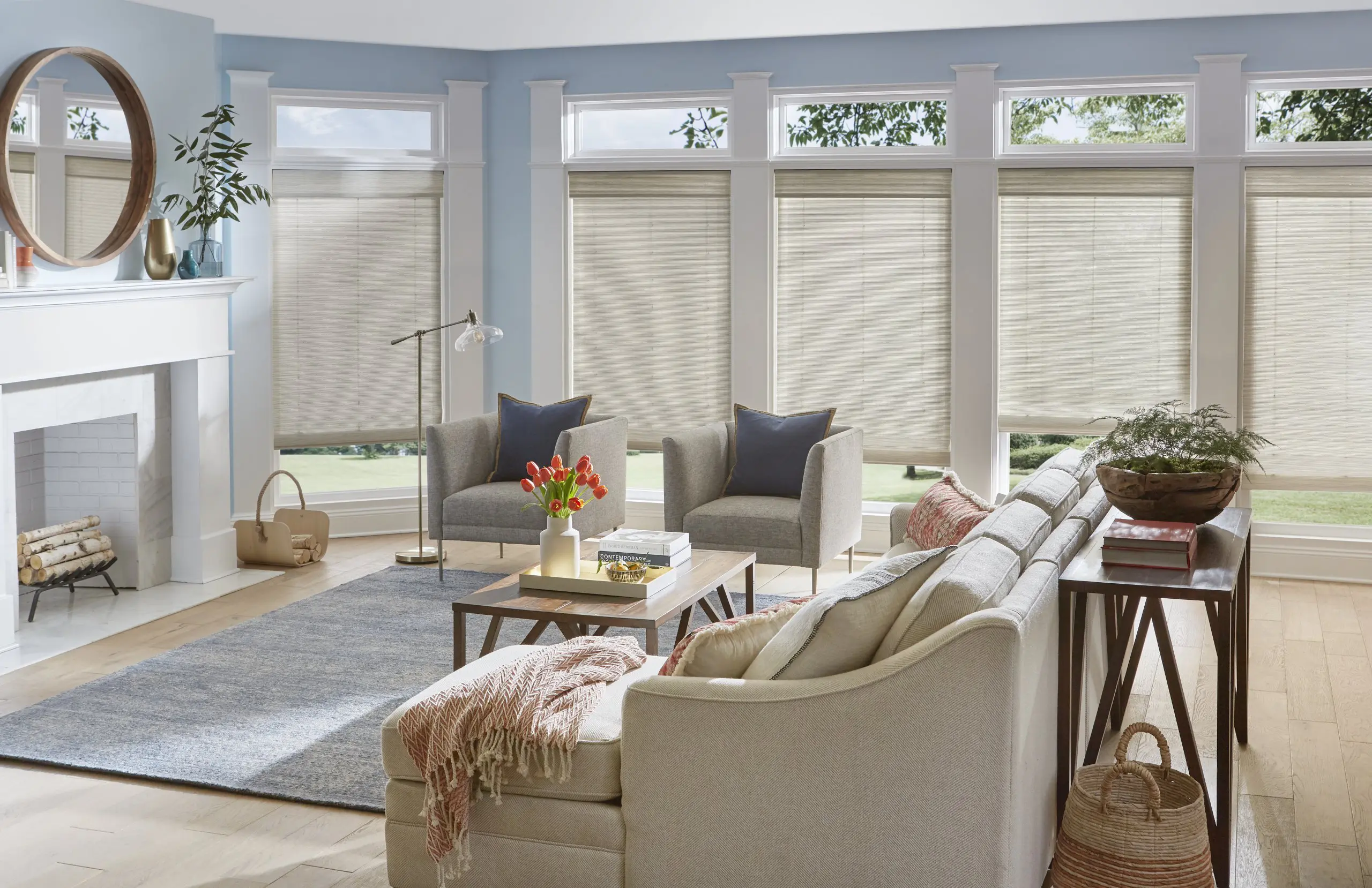 Woven shades cover floor to ceiling windows keeping the space bright but reducing incoming light